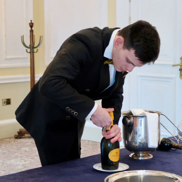 Erazem Ocvirk opening a wine bottle